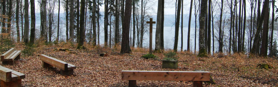Andachtsplatz mit Bänken und hölzernem Kreuz